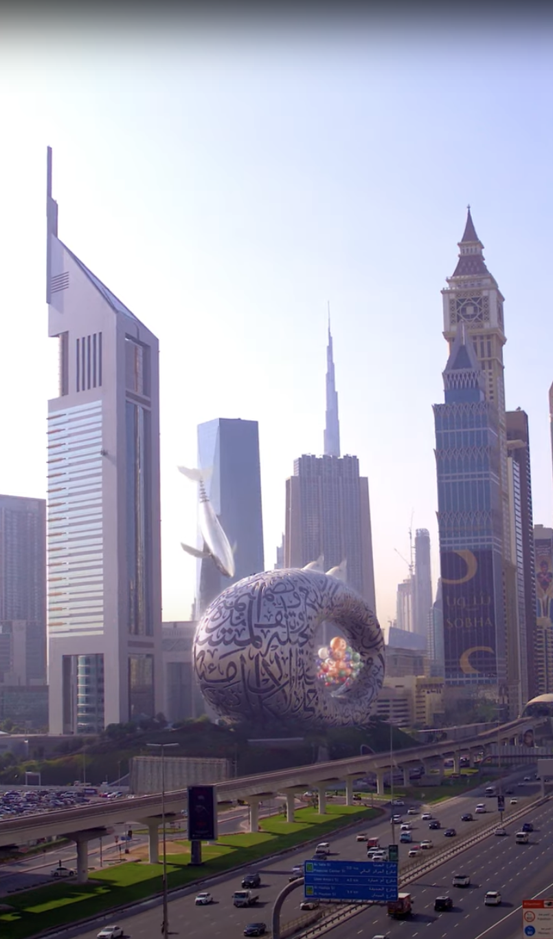 Metal whale gliding near Museum of the Future in Dubai skyline.