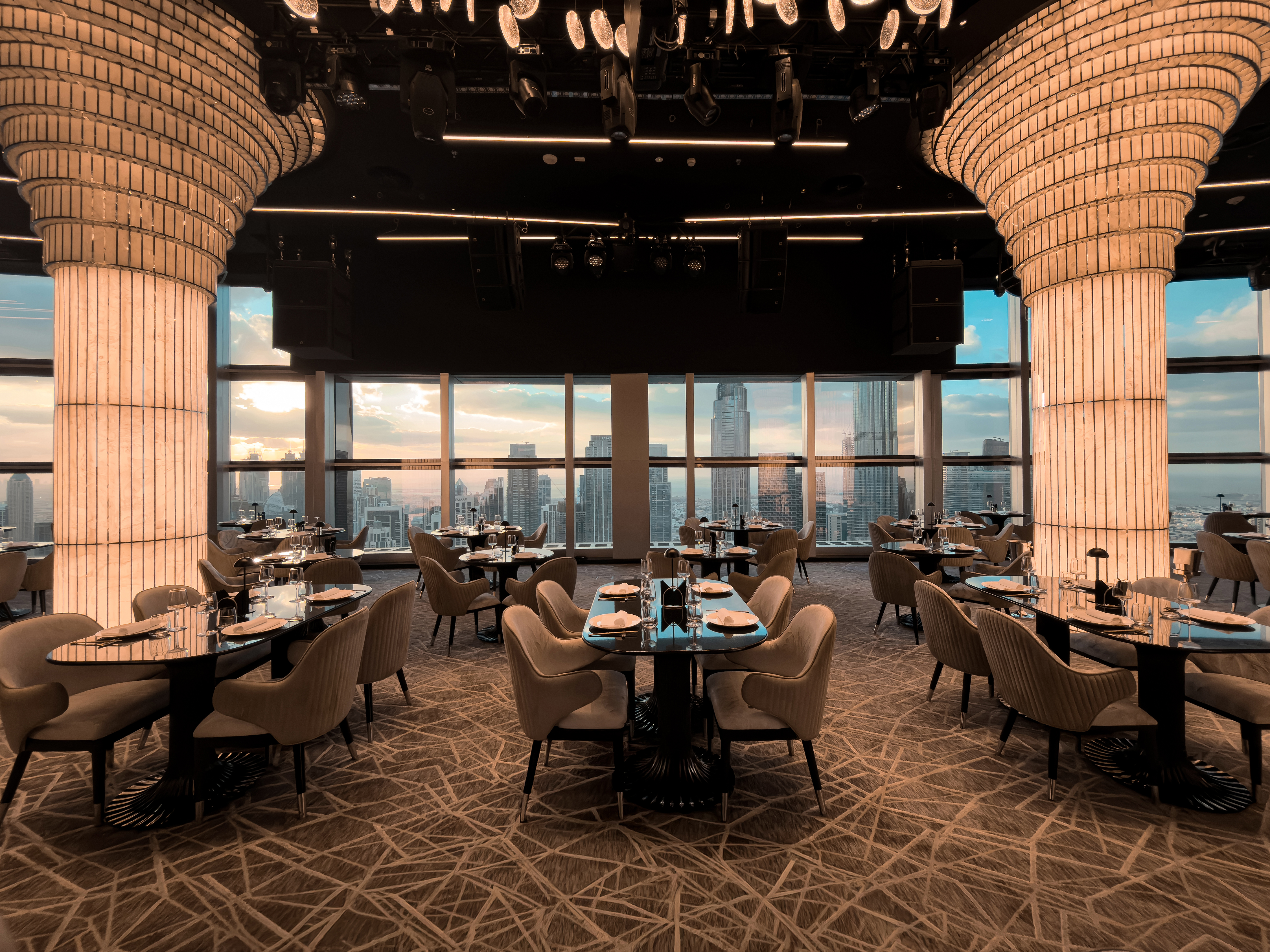 BIRDS Dubai dining room with illuminated columns and skyline windows.