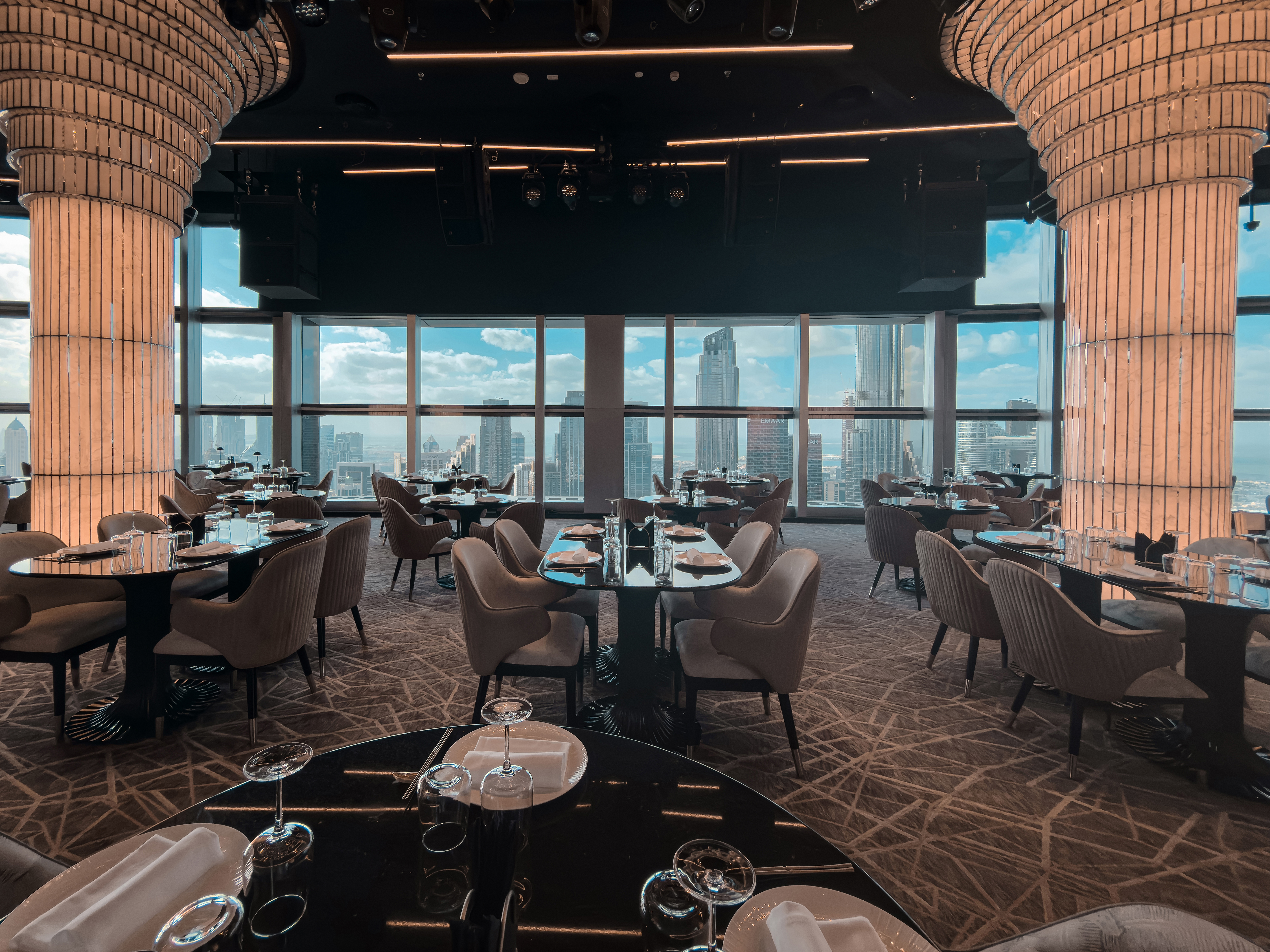 BIRDS Dubai dining table beside a skyline window.