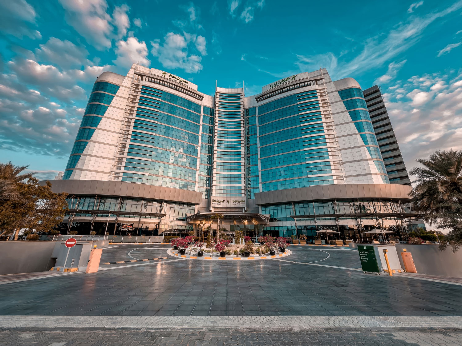 Holiday Inn Abu Dhabi exterior facade with dramatic sky.