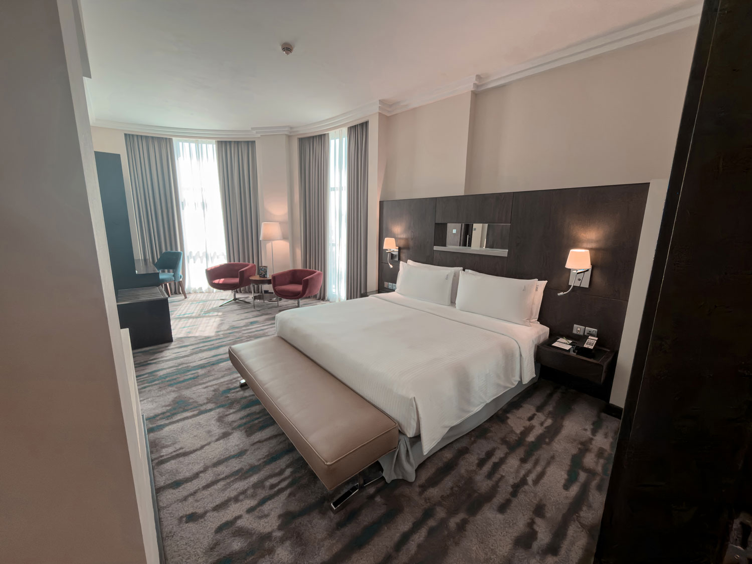 Holiday Inn Abu Dhabi guest room with bed and lounge seating.