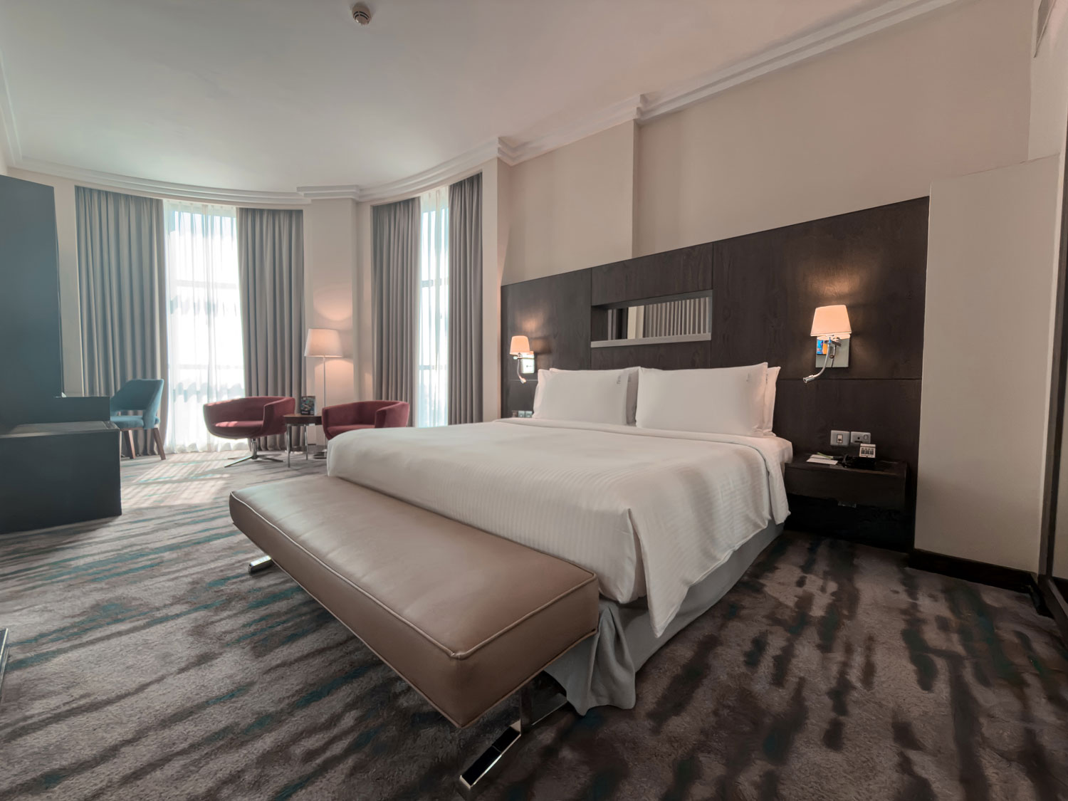 Holiday Inn Abu Dhabi guest room with king bed and seating area.