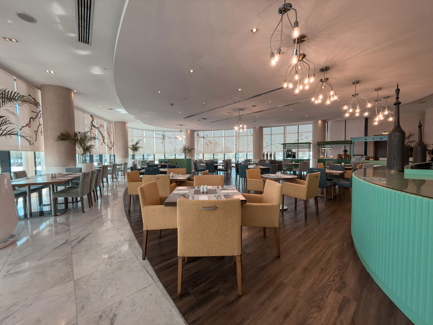 Holiday Inn Abu Dhabi restaurant dining room with teal counter.
