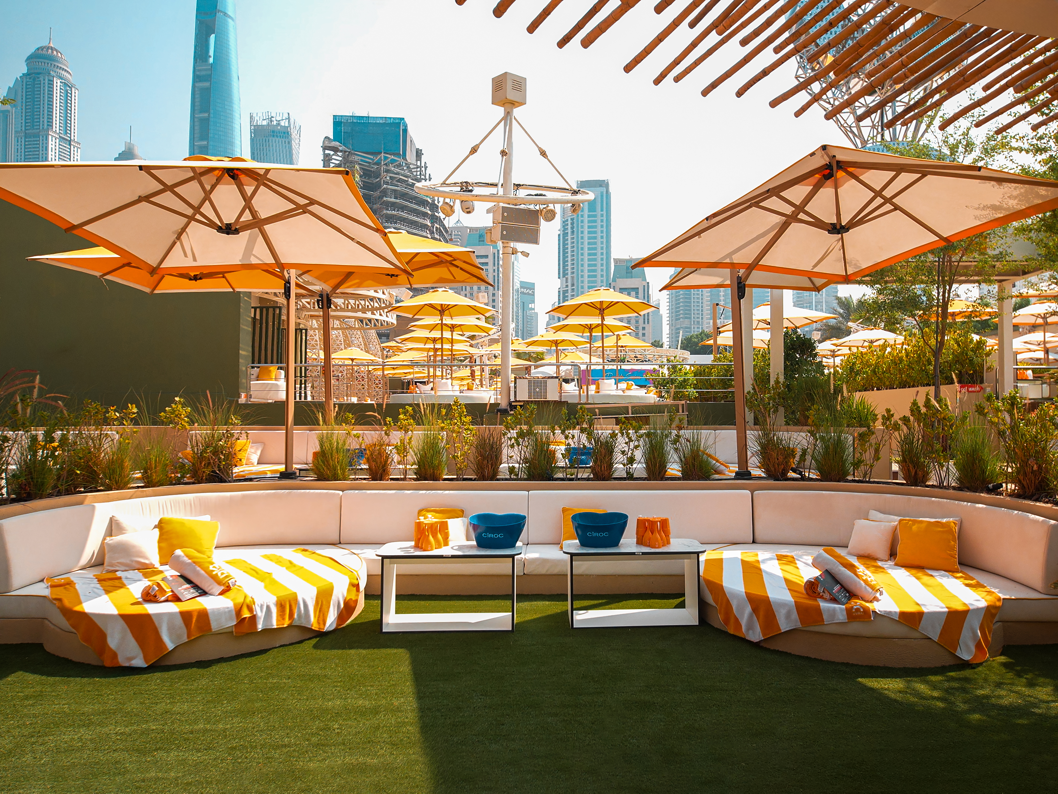 Private cushion lounge at O Beach Dubai with striped sunbeds and umbrellas.