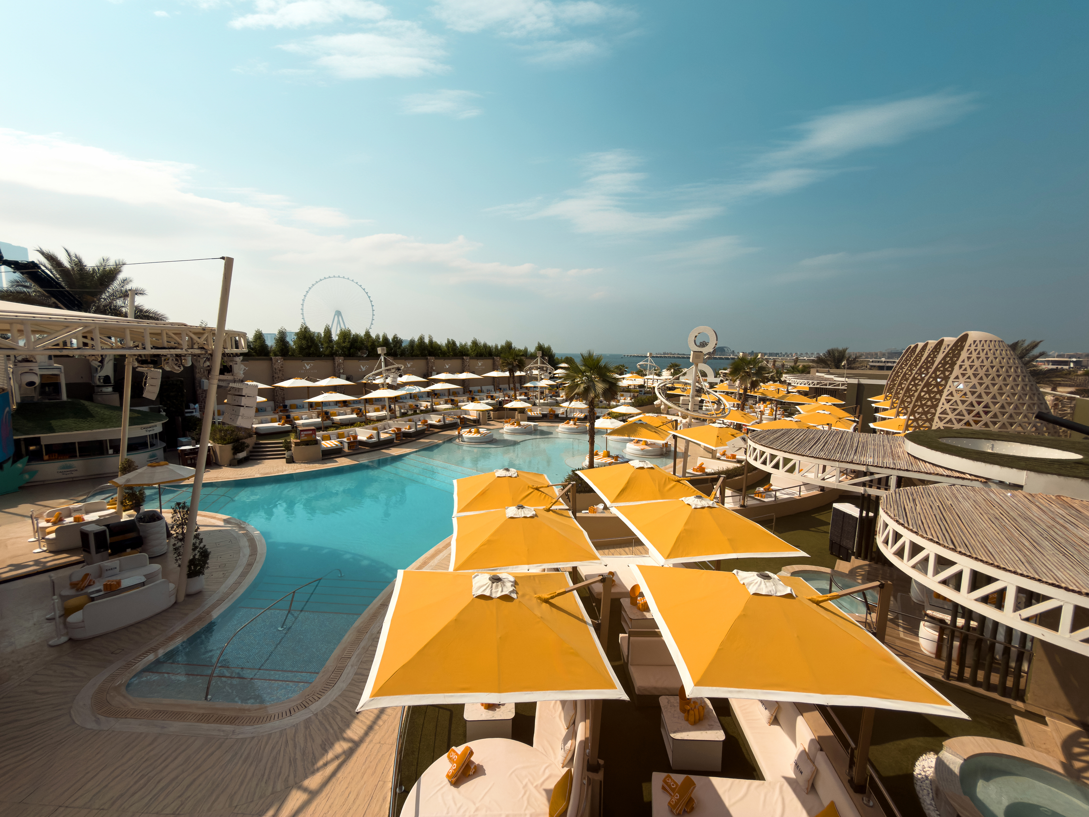 Elevated view over umbrellas and the O Beach Dubai pool.